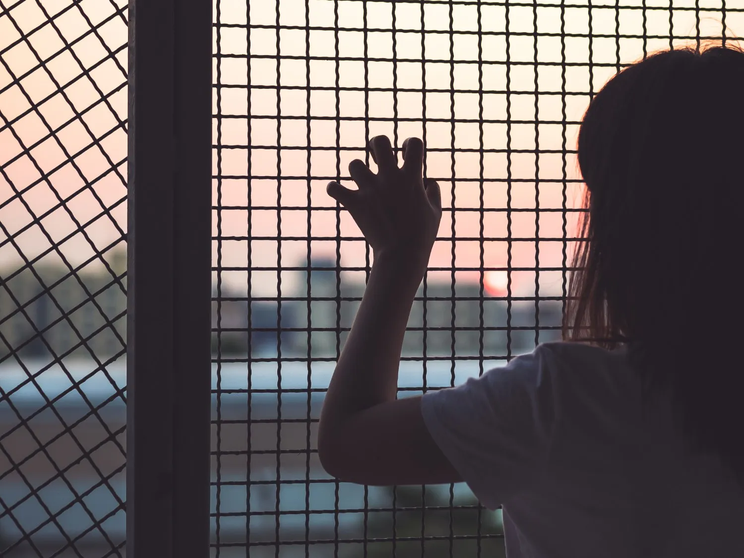 Lady with hands on a cage
