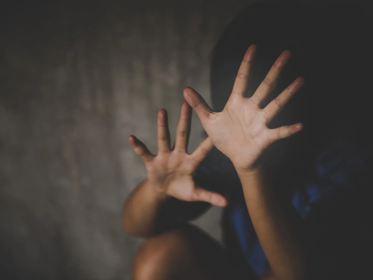 Scared child with hands up - trafficking concept
